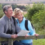 Middle-aged Couple, examining map, while hiking in the woods